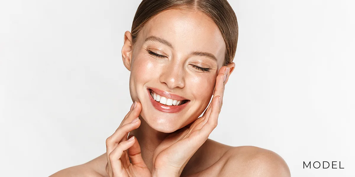 Female Caressing Soft Skin on Face with Hands